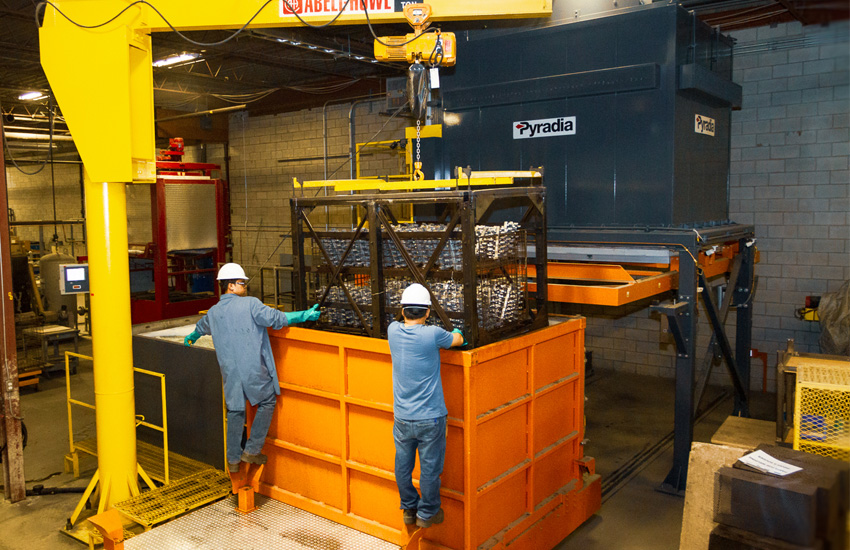 Workers doing heat treating with machinery