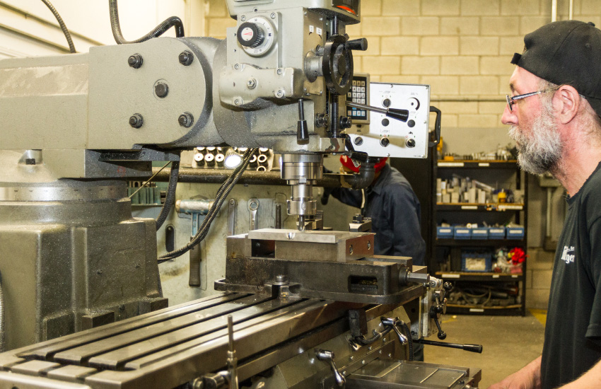 Homme devant une machine perforatrice